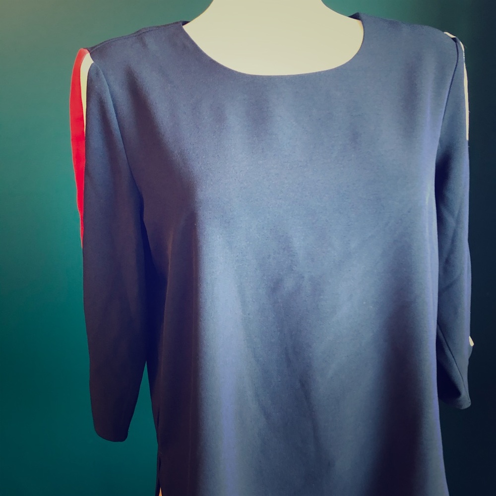 Business casual navy top with red striped sleeves.